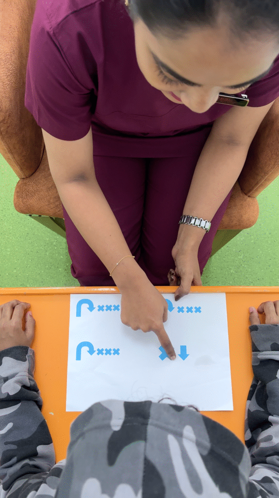 Therapist at the best speech therapy center in Dubai guiding a child through a visual direction-following activity.
